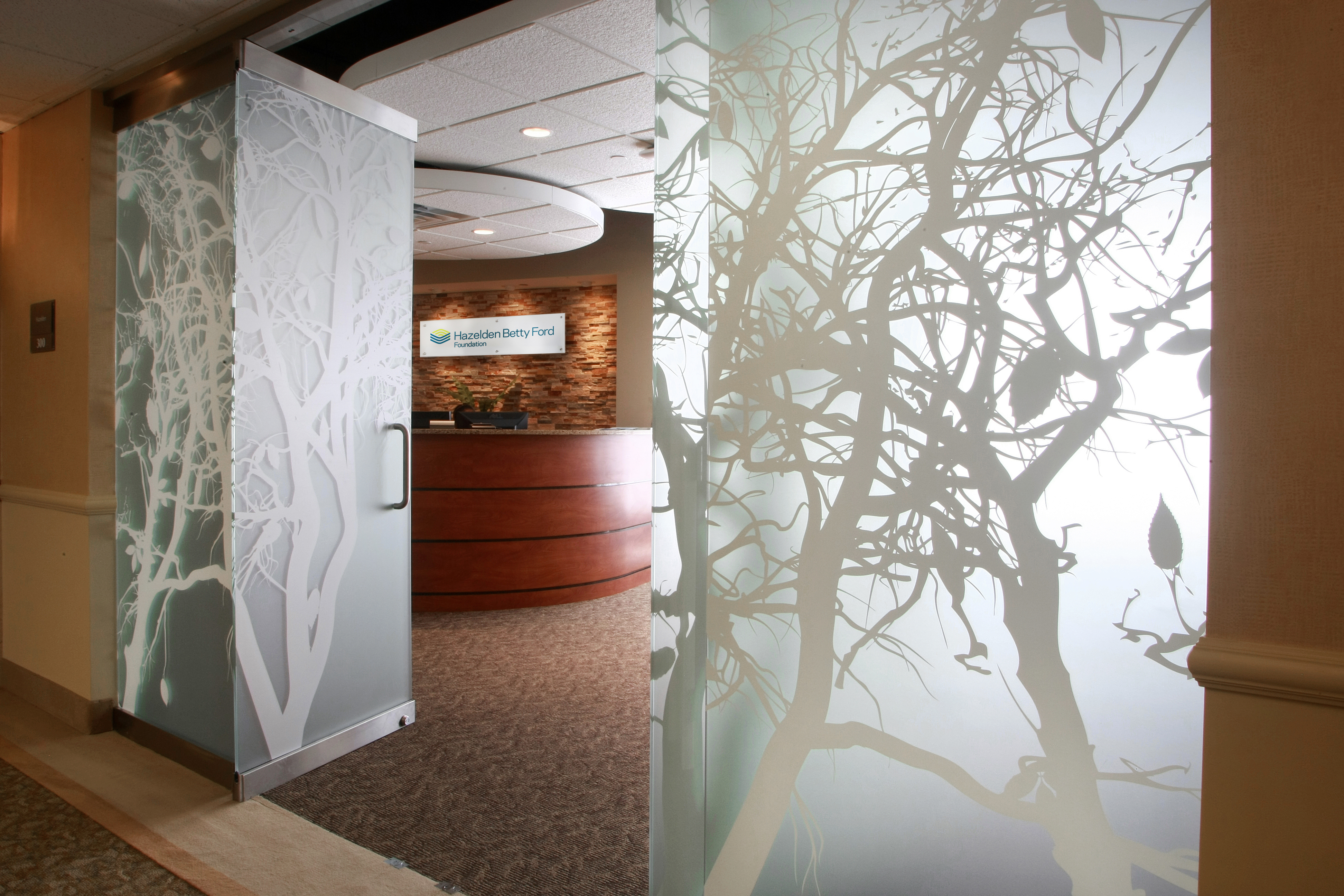 A view of the entrance with frosted doors and a drop-down cloud ceiling